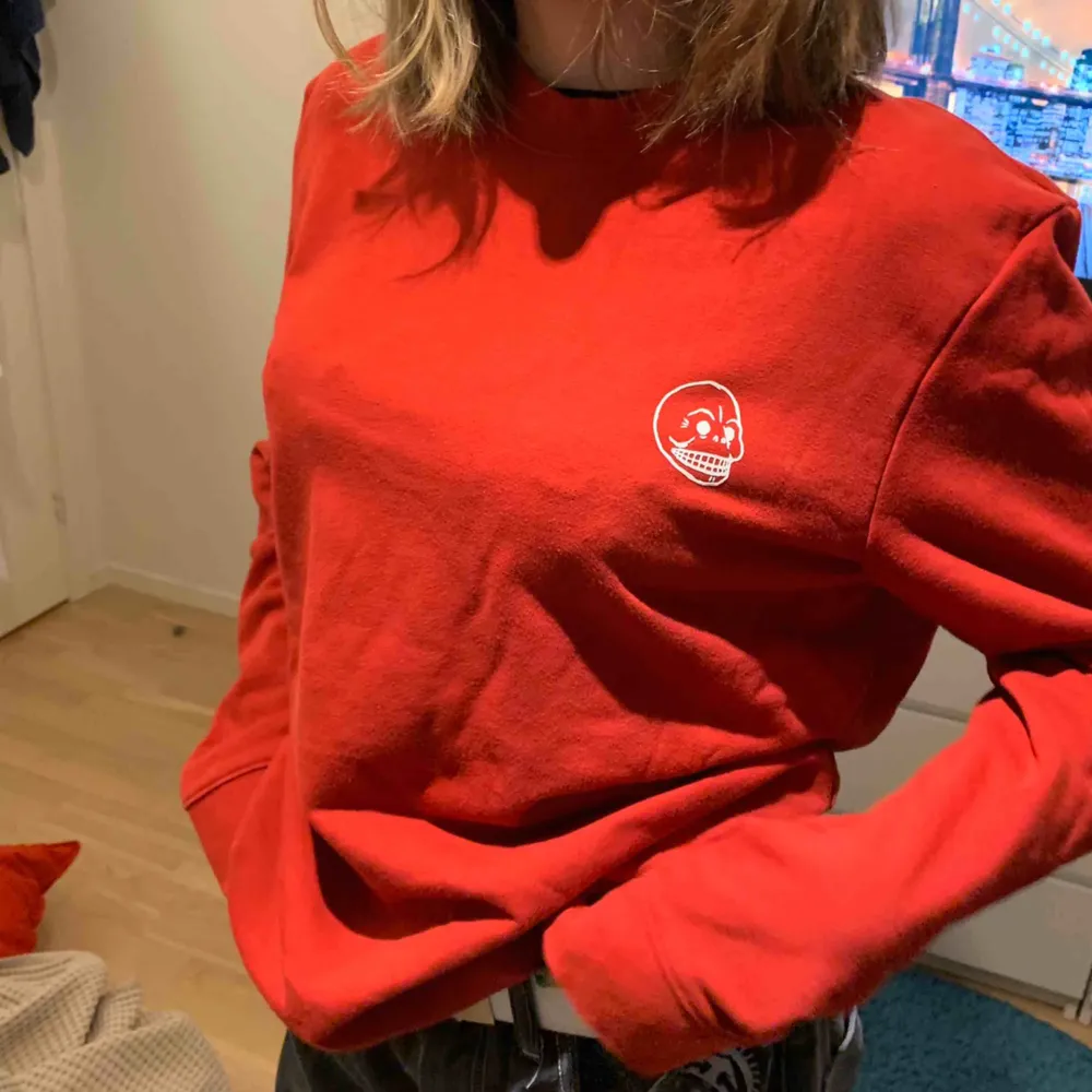 Härligt oversized röd sweatshirt från Cheap Monday. Vitt motiv på bröstet som föreställer en dödskalle (märkets logotyp). . Hoodies.