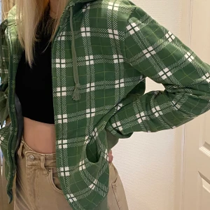 Grönrutig zip-hoodie - En skön hoodie med dragkedja och snöre. Storlek M men känns mer som S. 