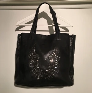  - Svart handväska med vingar i strass, dragkedjor i sidorna.