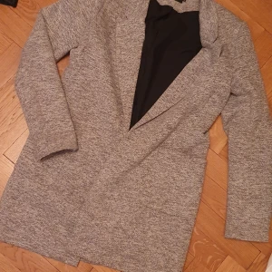 Grå Tunn Kappa (tall) Storlek 40 - Tunn grå kappa passar bra vår/höst i storlek 40. Märke only (tall collection). Använd en säsong.