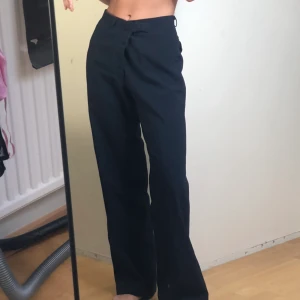 Raka kostymbyxor - Mörkblå raka kostymbyxor. Jag är en 34-36 så dessa är lite stora, men jag brukar använda dem genom att trä in den andra kroken i hålet så dem sitter tightare i midjan. Tror dvs att dessa kan passa en 34-38 beroende på passform man önskar.