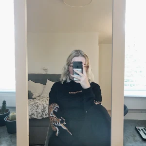 Hoodie med tryck  - En svart hoodie ifrån H&M med tiger tryck på armarna samt text på framsidan💕 Snöre i luvan saknas tyvärr men det är inget som märks😊