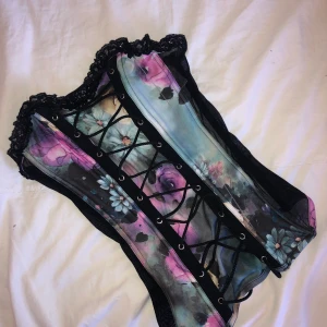 Mönstrad Korsett-top - Sjukt vacker och väldigt bekväm korsett | stretchiga tyg och svart när i sidorna, snörning fram och bak | långa snören gör storleken väääldugt flexibel | använd 1 gr, köpt på en second hand | en reva i fram som syns på bilden! 