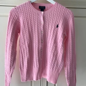 Ralph Lauren cardigan storlek XS - Helt oanvänd kabelstickad kofta från Ralph Lauren. Prislapp sitter kvar. Färg: carmel pink. Storlek: XL/TG (16) barnstorlek, men skulle säga också passar dam i XS.  Frakt tillkommer