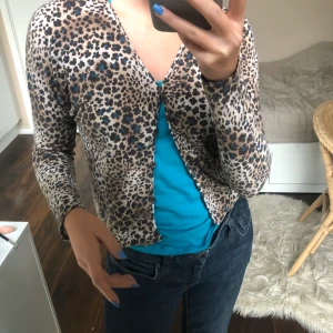 Leopard cardigan - Säljer en Supersöt leopard tröja med knappar som jag köpt här på plick men som jag tyvärr säljer pga att den används för sällan.Jag kan mötas upp i Stockholm eller frakta mot att köparen betalar frakt😊