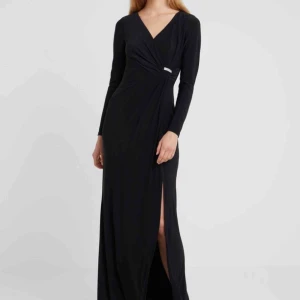  - Vacker, oanvänd hellång svart klänning från Ralph Lauren! Köpt i början av sommaren, men tillfälle gavs aldrig att använda den. Strl 42 men är aningen mindre i strl! Glittrigt spänne i sidan, omlottmodell över bysten. Stilfull slits på vä sida. 