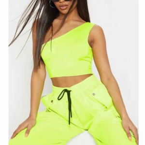  - En neon gul/grön topp. Lite genomskinlig, jag skulle ha haft någon slags bh/top under 