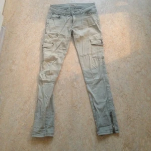 Byxor från Serious Sally. Ljusgröna med flera fickor och dragkedja nere vid ankeln.  - Byxor från Serious Sally. Ljusgröna med flera fickor och dragkedja nere vid ankeln. 