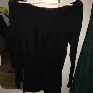  - En svart tunn tröja med en sträng i mitten fram