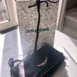  - Väska från Zadig et Voltaire. Den är använd, det märks däremot inte särskilt förutom att metallen ändrat en aning i färg. Detta ger dock en extra cool och egen look! Långt band medföljer⚡️⚡️ Nypris: ca 3500kr