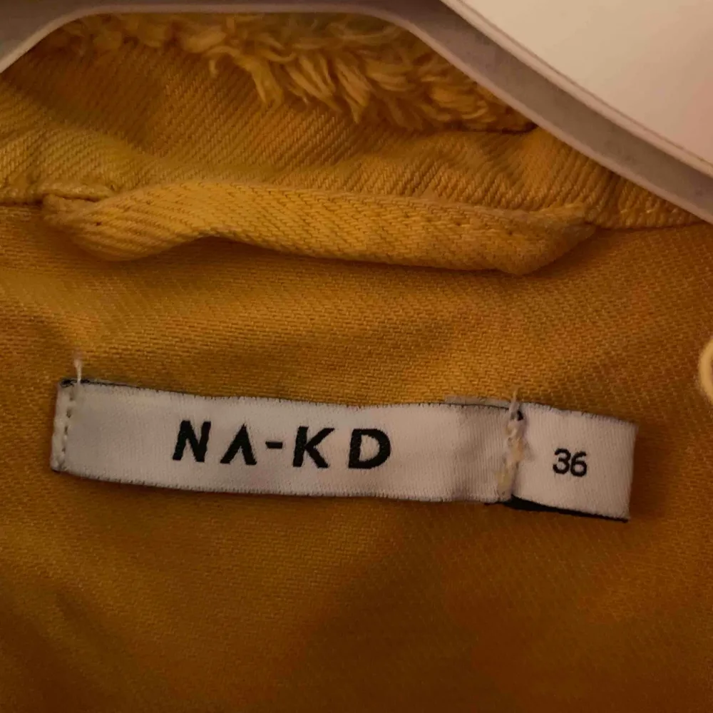 Helt ny croppad jeansjacka från NAKD. Jättefin gul färg och slitning. Endast provad inomhus. Köparen står för ev frakt 63kr med postnord.. Jackor.