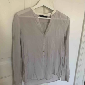  - Ljusgrå blus från Zara. Guldknappar. Sparsamt använd. Storlek medium. 