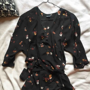  - svart/blommig knytblus från ginatricot