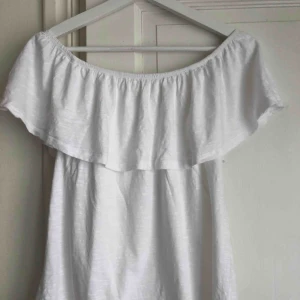  - En snygg, vit off-shoulder tröja 