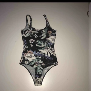  - En fin somrig body med tropiskt blommönster. Den har en djupare rygg se bild 3. Nyskick!  Frakt tillkommer:)