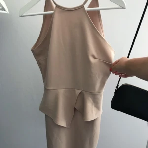  - Snygg festklänning i beiget med volang i midjan, skal-modell. Knytning i nacken, NYSKICK! 😊 (från Nelly)  40kr + ev frakt 🌸