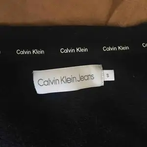 Svart Calvin Klein tröja med tryck. Ganska kort i midjan, storlek S. 