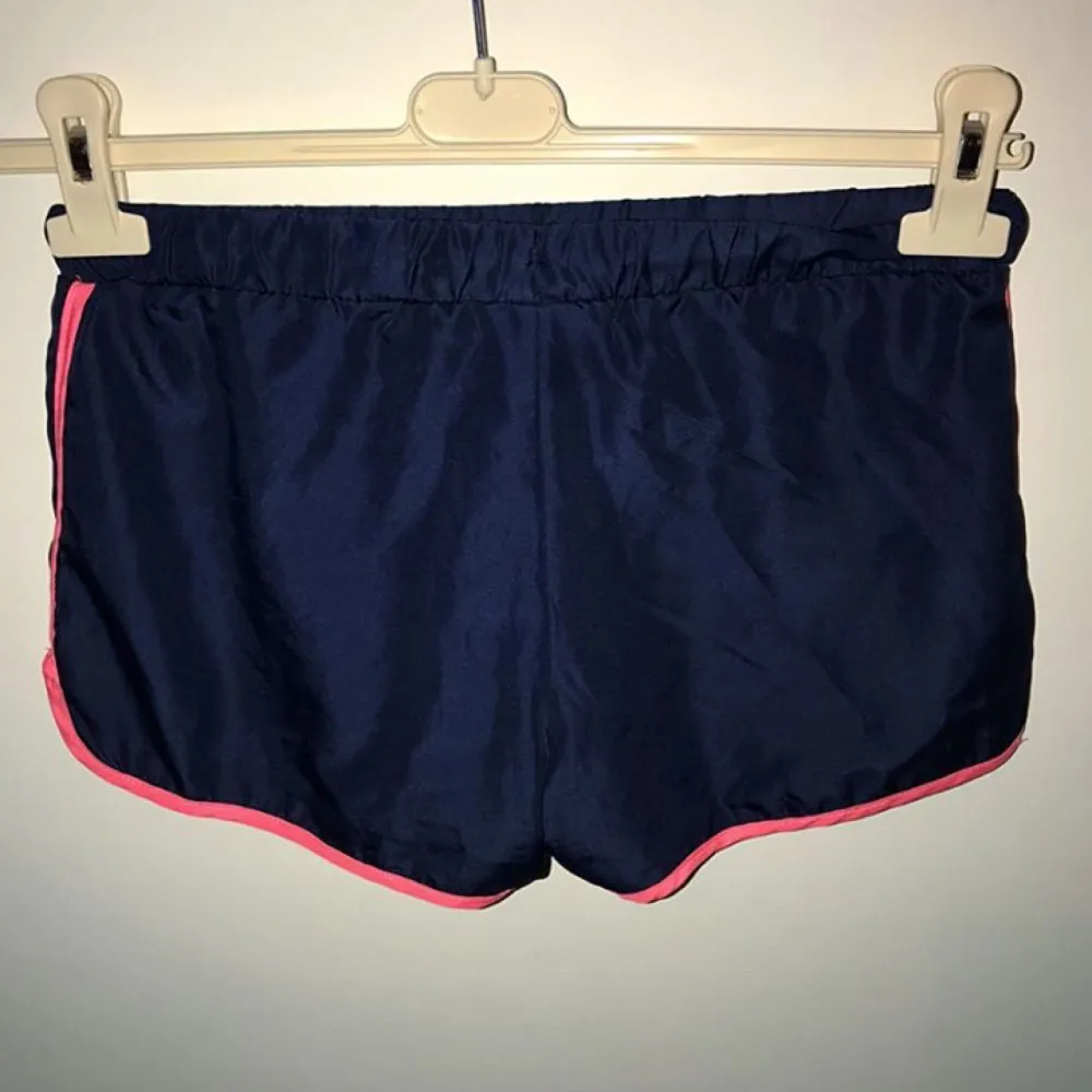 Marinblå & rosa shorts från Svea i storlek 140/150 vilket motsvarar XS!  Endast använd en gång!  Shortsen kan användas i träningssyfte likväl som att ha till vardags! . Shorts.