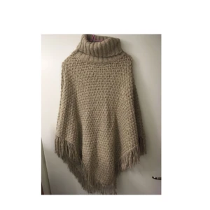  - Varm gråbeige stickad poncho inhandlad i Paris för ett par år sedan. Se gärna mina andra annonser, garderobsrensar denna vecka. 