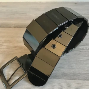  - Supersnyggt skärp av gråsilvriga spegelblanka ”metallplattor”, från någon av H&Ms specialkollektioner för flera år sedan men använt max 5 gånger. Storleken är XS, uppmätt till ca 90cm(exklusive spännet!) 