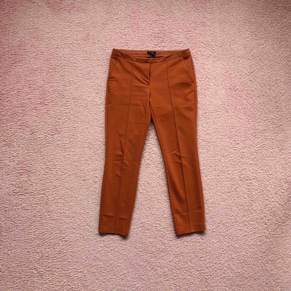 Low waist ankle kostymbyxor i en fin rost röd/orange färg. Väldigt fint nu i höst! De är använda, och i ok skick.. Jeans & Byxor.