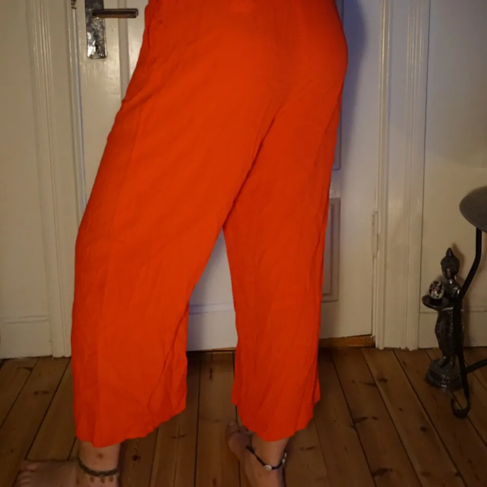 Härligt röd/orangea byxor! Mycket tunna och skönt somrigt tyg med ett snyggt skärp i samma tyg! . Jeans & Byxor.
