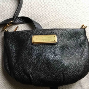  - Marc Jacobs handväska i svart läder. Mindre handväska med axelrem. Använd men fint skick, lite repor på mässingmärket men lädret helt utan skavanker.  Kan mötas upp i Stockholm eller postas. Köparen står för frakten.  