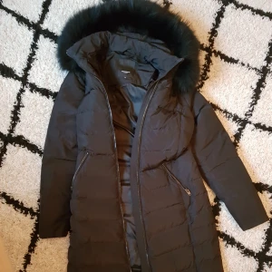  - Dunkappa från Rockandblue med äkta pälskant. (Köpt på butik i Farsta centrum/Stockholm). Endast använd 2 ggr vid korta tillfällen. Storlek 38. Säljes pga jag köpt en kappa som är oversize  istället. Helt nyskick och jättefin! Modellen 'Ariana' för den som vill bildgoogla:-)  Nypris 3499:-