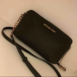  - Äkta michael kors jet set traven crossbody  Den är i fint skick men säljer den för det låga priset pga att jag råkade spilla limm i den lilla fickan inne i väskan som ni kan se på bild 3 annars är det inget fel på den😊 köparen står för frakt 