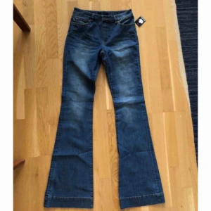  - HELT NYA bootcut flare jeans oanvända med lapp kvar! Hög midja, fickor, skärphylsor. Midjemått 70cm, innerbenslängd 82cm. Fina 70-talsinspirerade. Nypris 399kr