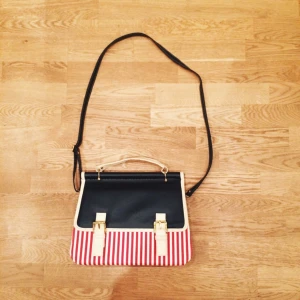 Röd/vit randig och mörkblå väska i skinnimitation med axelrem. I mycket fint skick,oanvänd - Röd/vit randig och mörkblå väska i skinnimitation med axelrem. I mycket fint skick,oanvänd