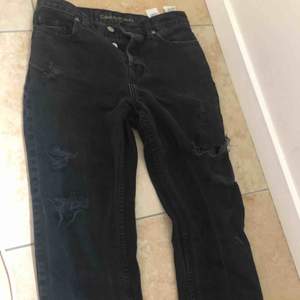 Svarta slitna Mom jeans från Calvin Klein (dom var slitna när jag köpte dom)  W25 L32  Köpta för ca 700-800kr  Betalning sker via swish Kan mötas k backa eller i slussen, om köparen vill ha jeansen skickade till sig betalar köparen för frakten:)