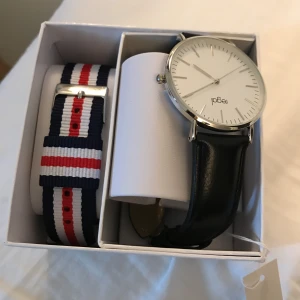 Klocka regal  - Oanvänd, super fint skick ordpris 600. Vet ej storlek det är en klocka man kan ju ändra men tror S ifall det är någon , svart band medföljer randigt blårödvitt! 