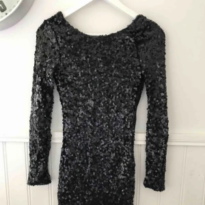  - Paljettklänning med djup rygg. Frakt tillkommer