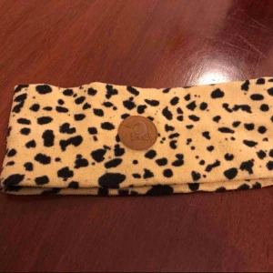  - Stilig. Head warmer. Av fleece material I leopard mönster. 