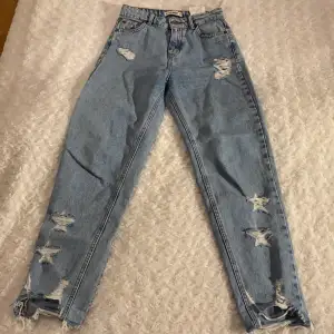Slitna jeans från Pull&Bear i storlek 32 💙💙 Jeansen har mom-fit och har fina slitningar i form av stjärnor ⭐️ Dem är i mycket fint skick och är använda max 1 gång! Samfraktar gärna med andra plagg och betalning sker via Swish <33