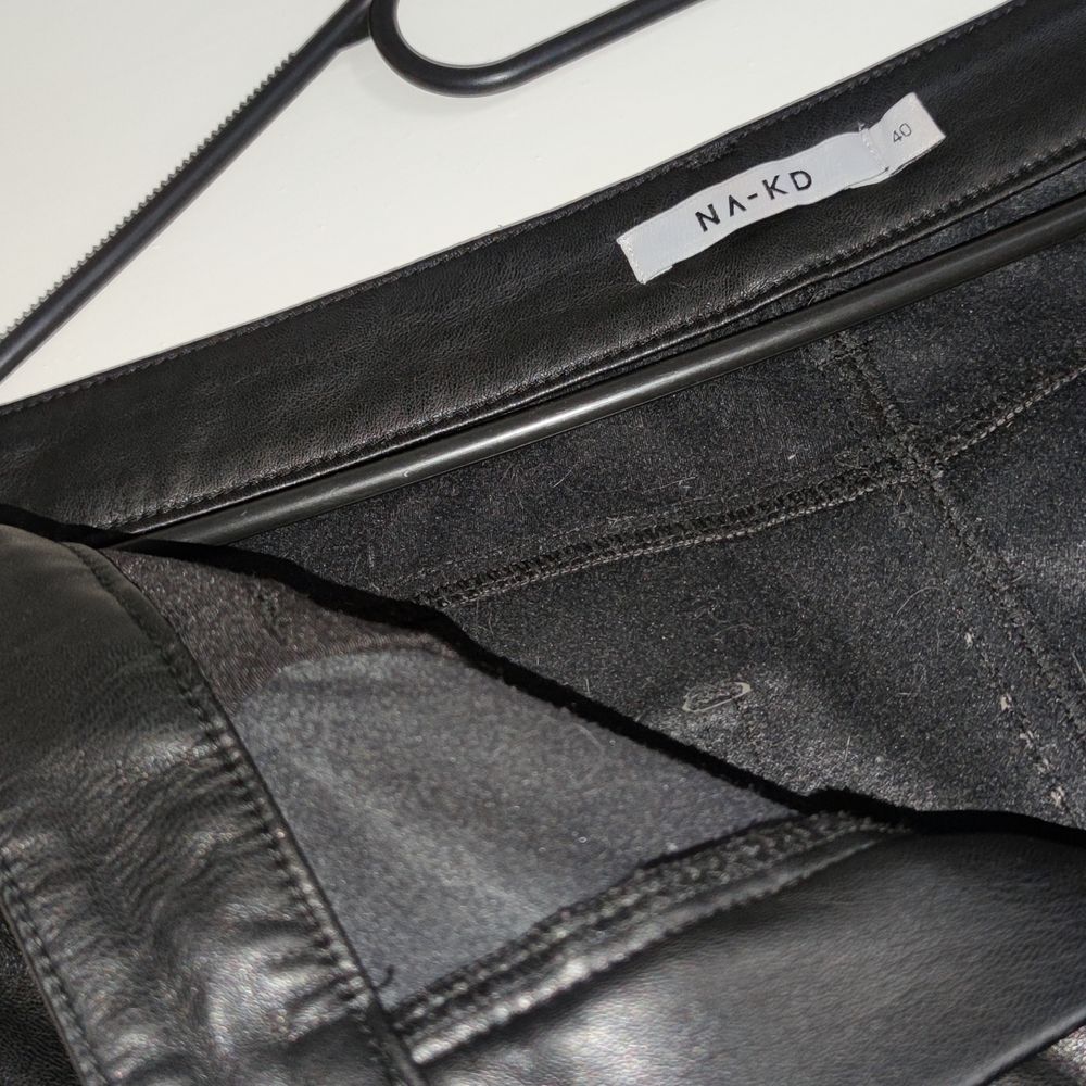 Fejk läder / faux leather byxor / trousers i tjockt tyg med foder från NAKD. Storlek 40 , passar medium. Svag söm bak i gren och två små hål vid främre bälteshållare ,syns ej om man inte drar hårt i byxorna. Knappt använda ,skador skett pga för små. Tjockt läder tyg.. Jeans & Byxor.