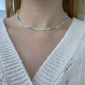Blått, grönt & vitt pärlhalsband med små pärlor🤍🦋💚🍭💕💙🐢 halsbandet försluts med lås och tråden är elastisk 