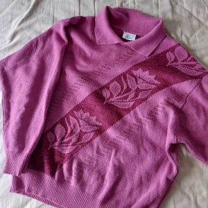 Vintage stickad tröja - En rosa stickad tröja med rosor på, har också krage vilket är najs. Säljer då den är lite kort i armarna på mig som är 181 cm:) lite stickig men funkar finfint om man har en tunn tröja under som jag har på bilden. Så fin men kommer inte till användning😔 