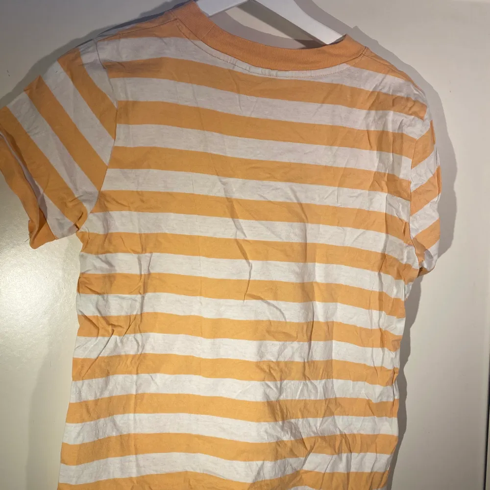 Orange/vit randig t-shirt med logga mitt på bröstet. Köpt på Carlings. T-shirts.