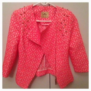  - Korallröd kavaj med nitar och dragkedja. Oanvänd! Storlek 36 men passar en 38 också. Kan användas som jacka under sommaren.  Portot betalar du