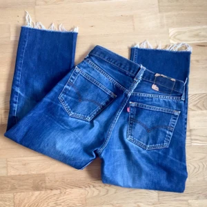  - Urban outfitters insydda Levis jeans.  Dom är insydda vid midja för en bättre passform för tjejer med smal midja och bredare höfter.  Avklippta ben.  Den är en fläck på ena benet, syns knappt pga hål runt om.  Frakt tillkommer.