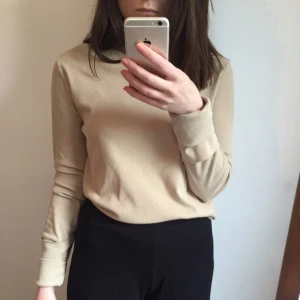  - Oanvänd ribbad topp med fastsydda uppvikta ärmar. 