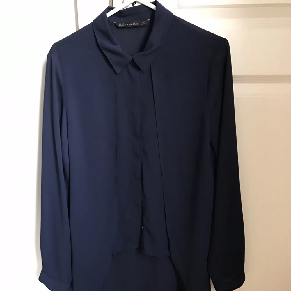 Mörkblå volang blouse från Zara i fin skick. Säljes pga fel storlek. Storlek M. Blusar.