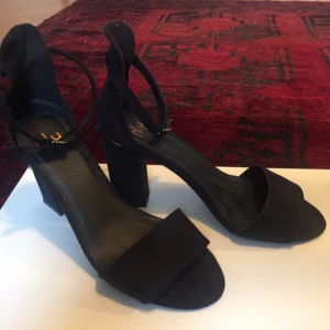  - Svarta klackskor från Nelly.  Höjd ca 9 cm. Knappt använda.