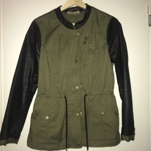  - Snygg näst intill oanvänd grön jacka med ärmar i läderimitation. Resår i midjan.   Kan skickas mot betalning. 