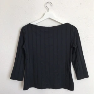  - Svart, randig topp med boatneck-urringning och 3/4-armar. Köpt på Humana Second hand. Elastiskt material, passar Small!   Köparen står för ev. fraktkostnad!