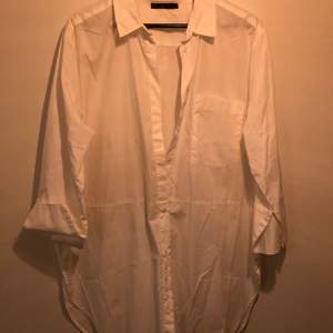Stor vit skjorta från Åhléns storlek 46. Ärmen tre kvarts lång. En bröstficka. Ryggen rundad nertill. 