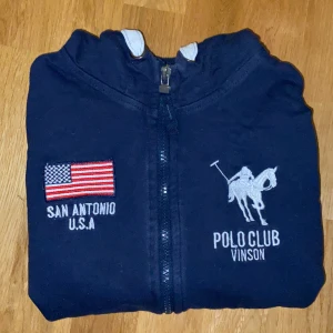 Vinston polo club kofta - Kofta med luva i bra men använt skick. Strl 140 och skulle vara en fin present till exempelvis barn, syskon, kusinen eller också dig själv! Köpte på killavdelningen men jag har använt den själv och det funkar lika bra till en tjej :) (köparen står för frakt, plagget finns kvar tills det står att den är såld)