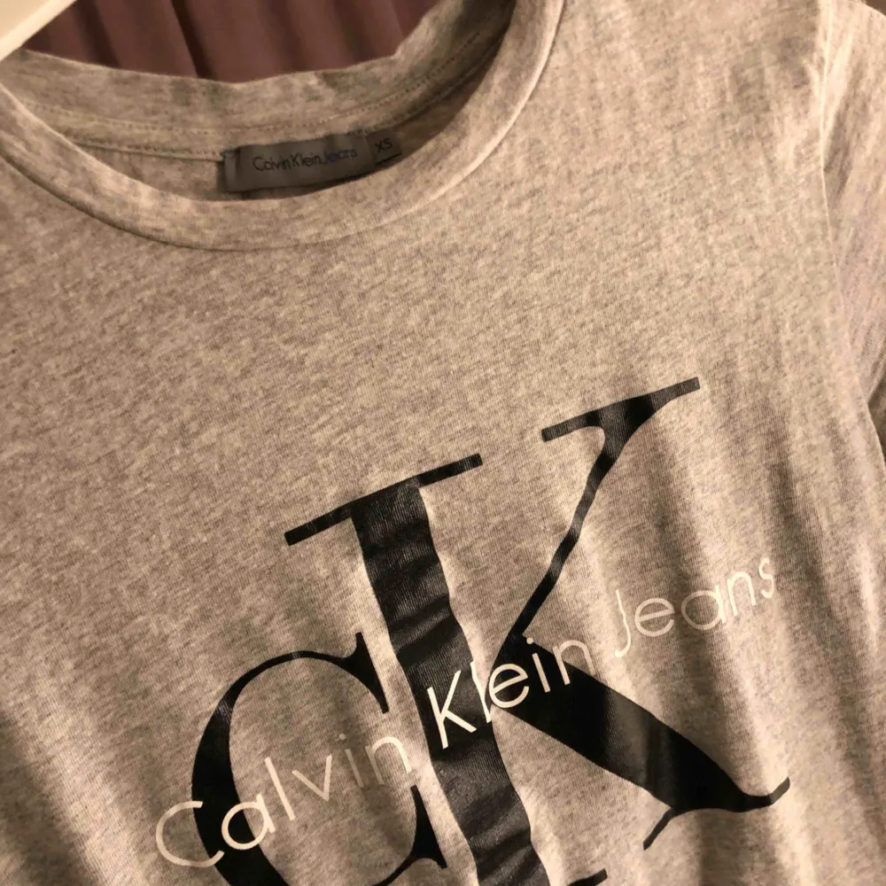 Säljer en ljusgrå Calvin Klein tshirt som knappt är använd. Frakt tillkommer! . T-shirts.